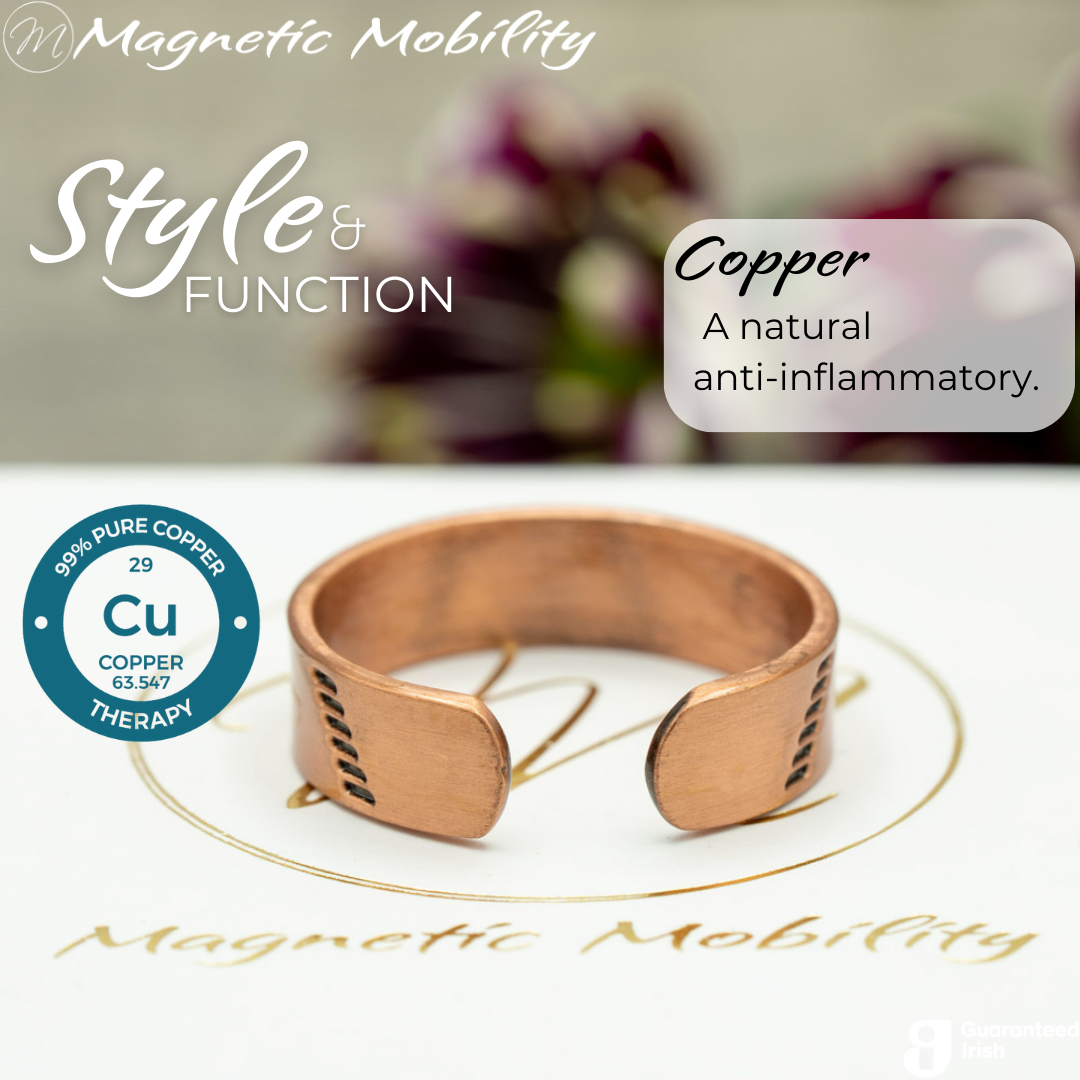 Back view of the Soloman copper ring from Magnetic Mobility. Shown on a white gift box with purple plants in the background. The writing says "Style and Function". The back is open to allow for swelling of arthritic fingers. 